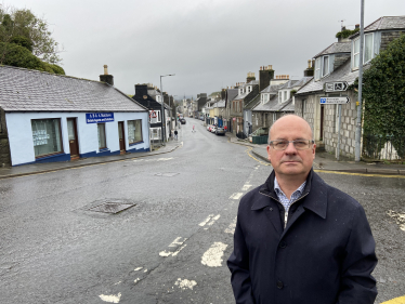 John Cooper looking towards camera on Victoria Street, Newton Stewart.